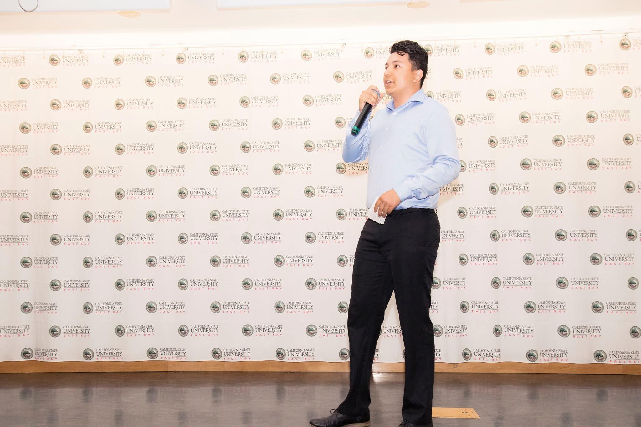 Joey speaking on stage at a Startup Weekend event